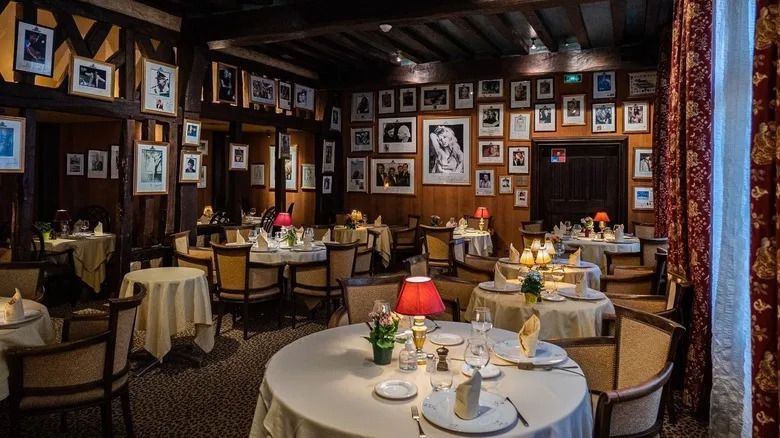 pictures of celebrities on the wall, including Child, surrounding dining table at La Couronne