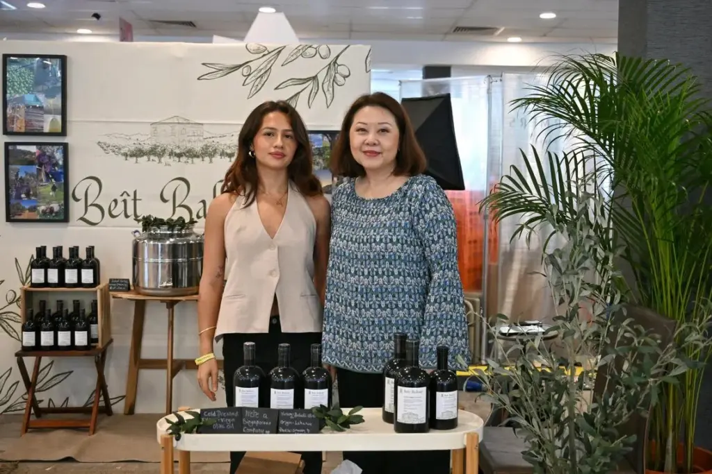 Meet the Singaporeans who run an eco-friendly olive farm in southern Lebanon Ms Mae Lam (right) and her daughter Alia Ballout promoting their olive oil during the Boutiques Singapore shopping fair at the F1 Pit Building on Nov 20.