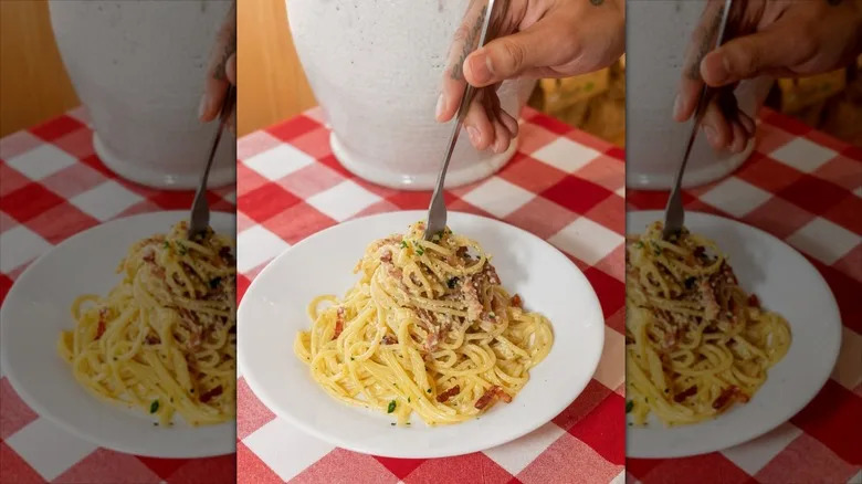 Creamy white sauce spaghetti twirled by fork