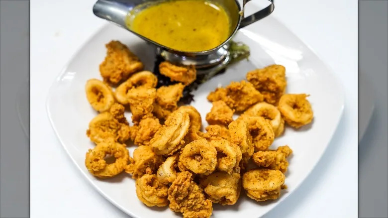 Fried calamari with side of dark yellow sauce