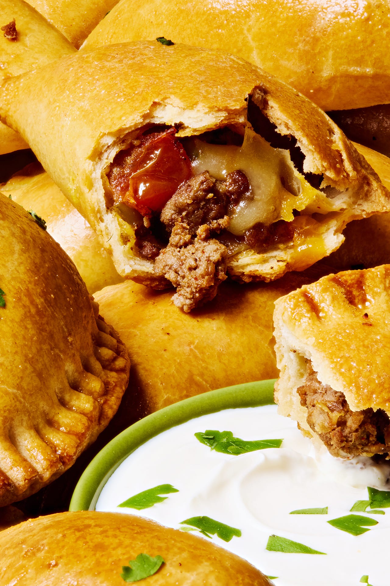 golden brown beef filled empanadas with a creamy dipping sauce