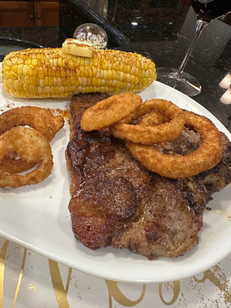 [homemade] 30oz porterhouse steak with onion rings and corn on the cobb.