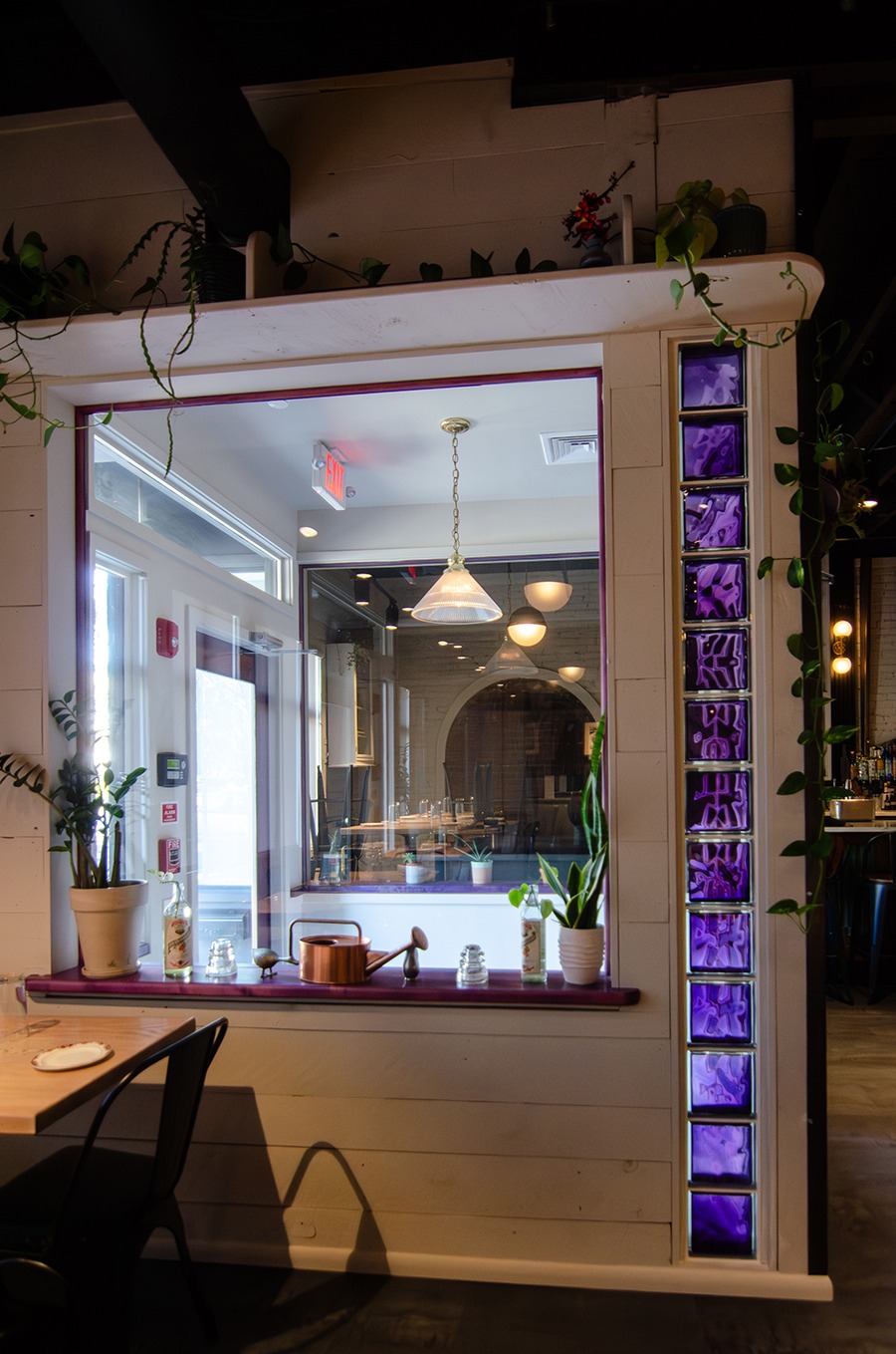 A vertical line of purple glass bricks adorns the entryway to a restaurant.