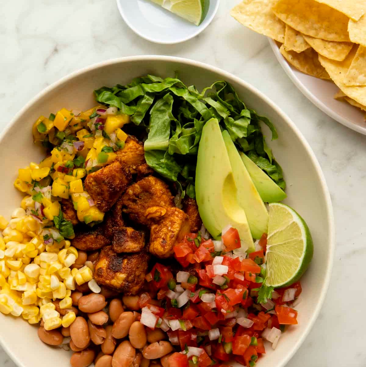 bowl filled with various fresh ingredients including beans vegetables and avocado
