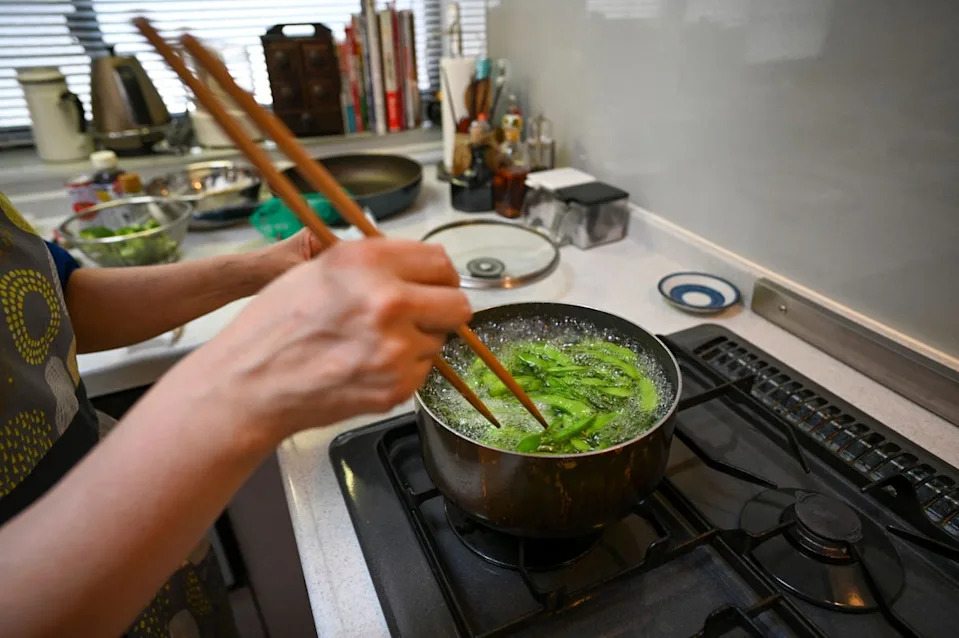 A woman boils edamame soybeans in Tokyo, Japan. Soybeans and other legumes are a major feature of the diet, providing ample plant protein (AFP via Getty Images)