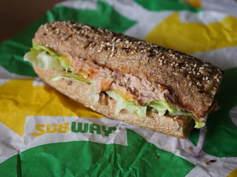 A "Tuna Sandwich" from the fast food chain "Subway" lies on a table.