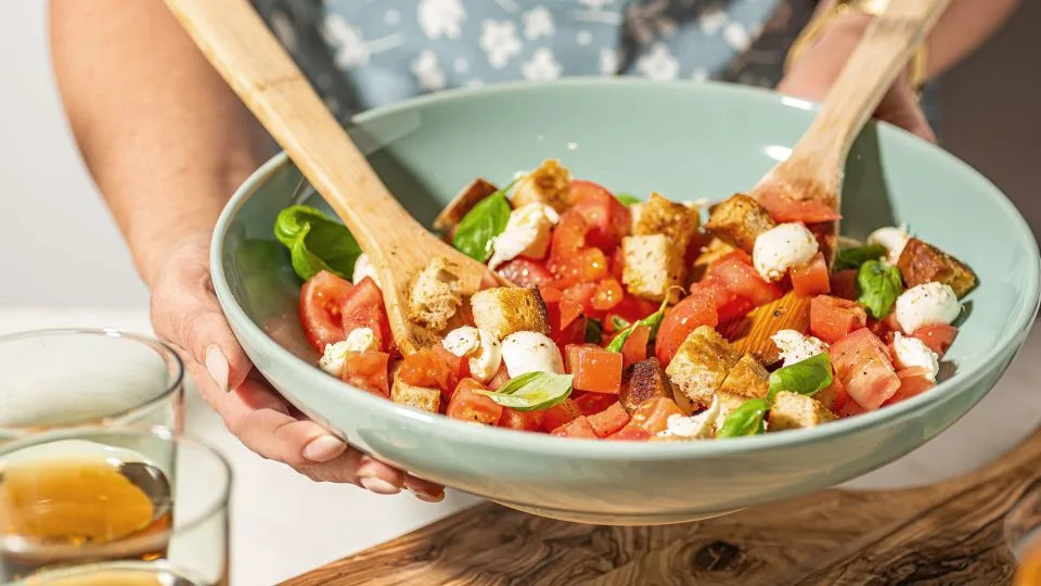 Tossed with tomatoes, basil, onions and olive oil, panzanella is a bread salad created by softening stale bread with water and/or vinegar. - Wirestock/iStockphoto/Getty Images