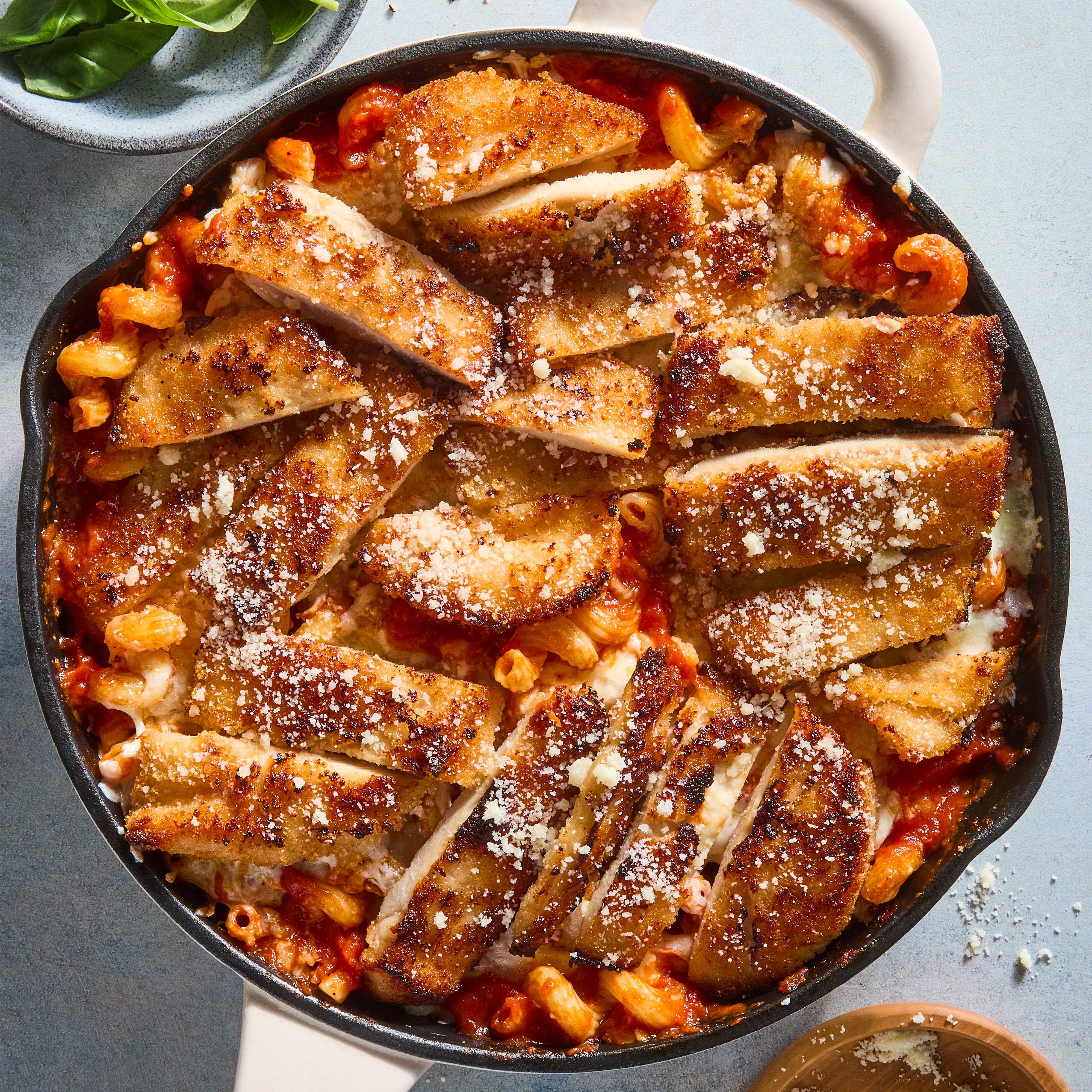 red sauce pasta topped with cheese and sliced chicken breast