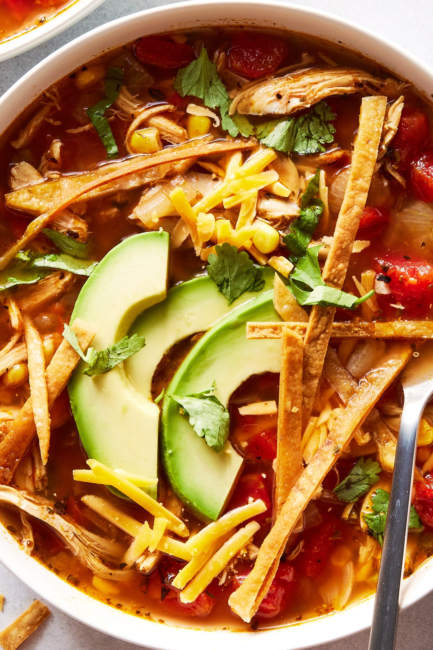 chicken tortilla soup with shredded chicken, corn, and tomatoes