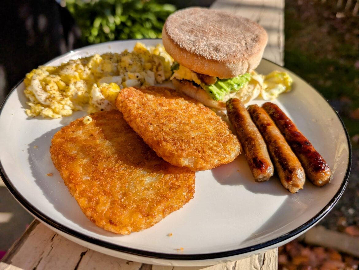 English muffin with scrambled eggs, sausage, avocado and El Yucateco green habanero. Hash browns, sausage and scrambled eggs on the side.