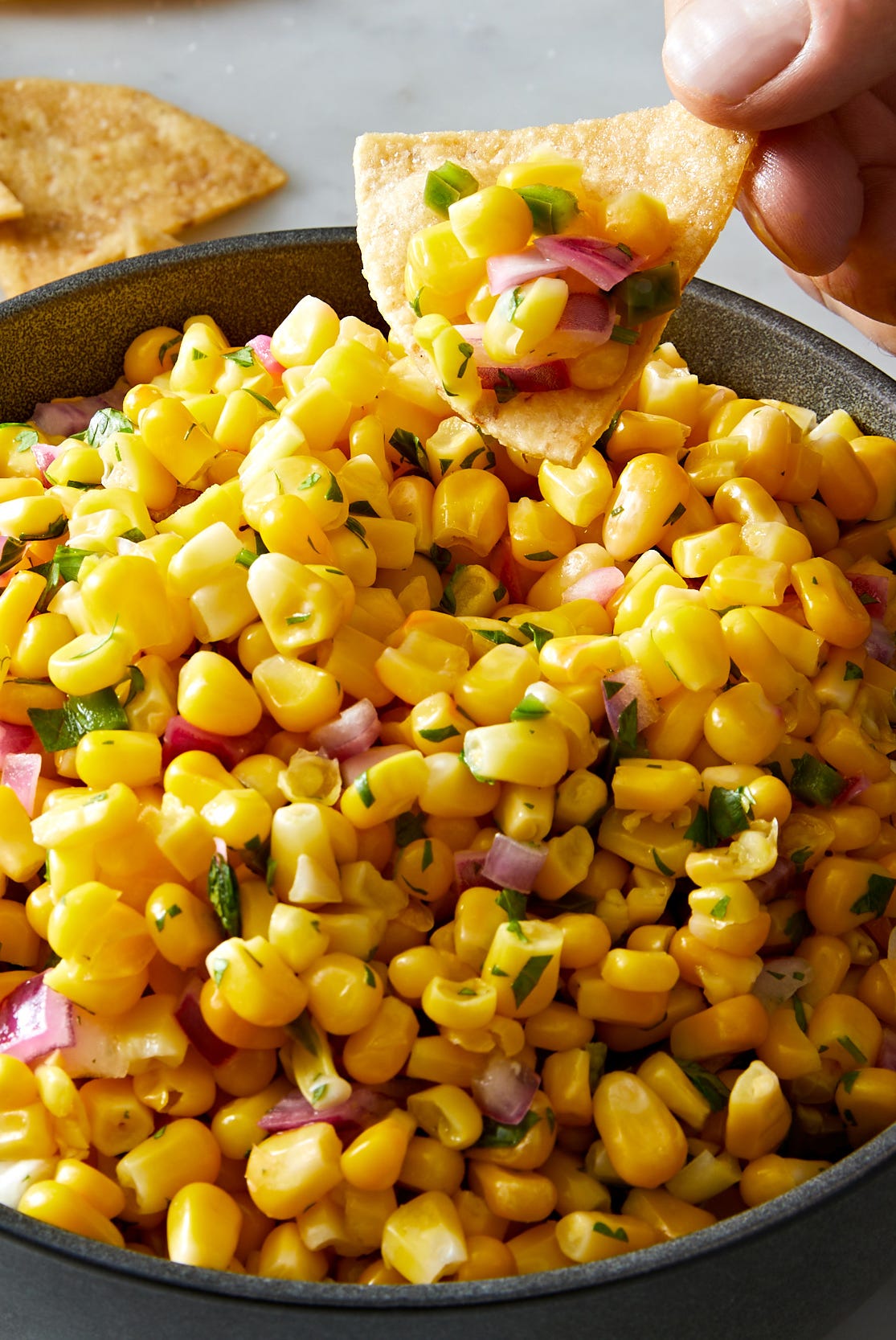 copycat chipotle corn salsa with corn, diced red onions, jalapeño and fresh cilantro