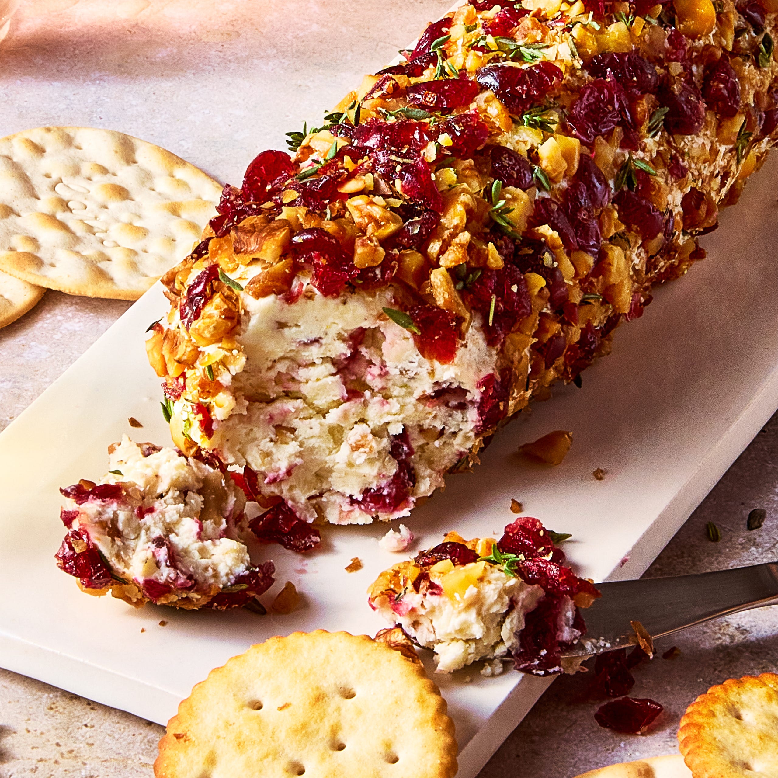 cheese log coated in chopped walnuts and dried cranberries