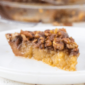 a side view of a crustless gluten-free pecan pie on a white plate