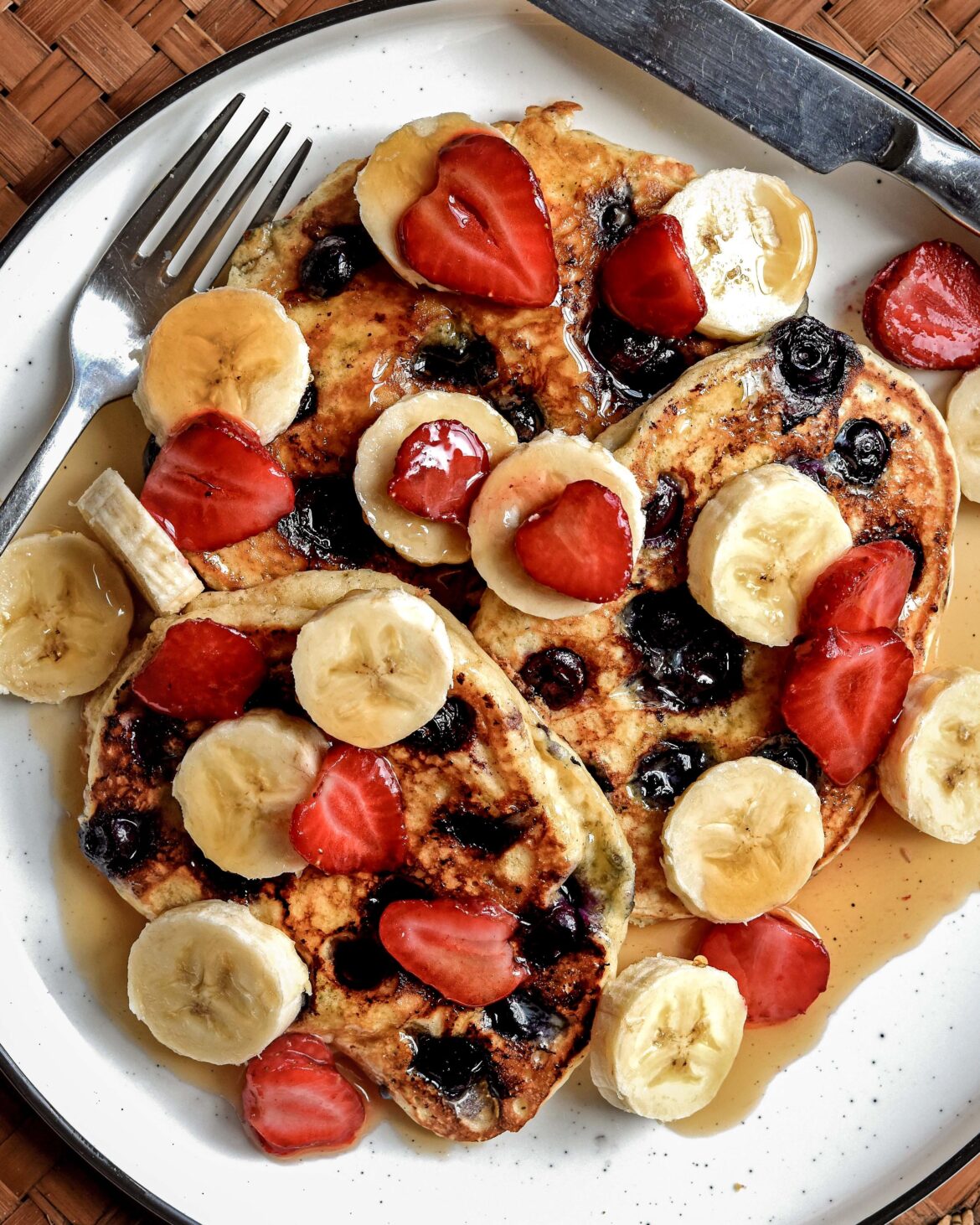 Blueberry pancakes with Strawberries, banana and syrup
