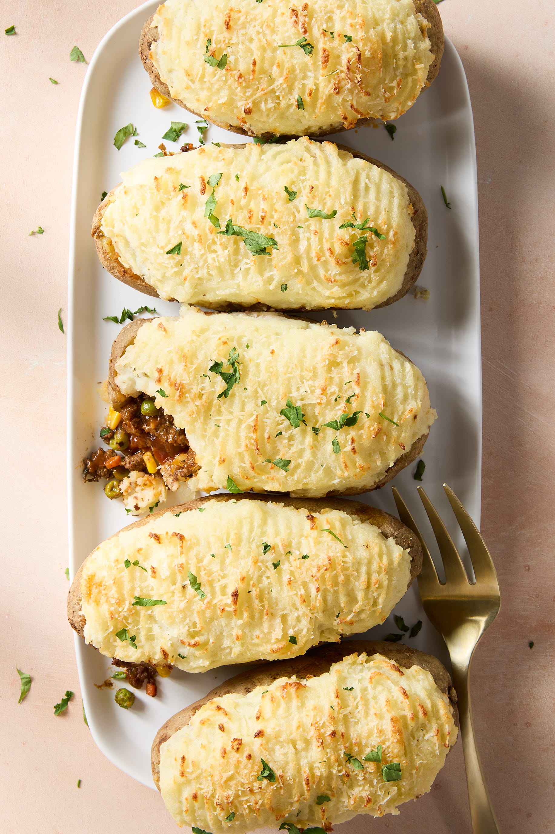 a saucy, red wine spiked ground beef and vegetable mixture gets loaded into hollowed out russet potatoes, topped with parmesan mashed potatoes, and baked until golden brown