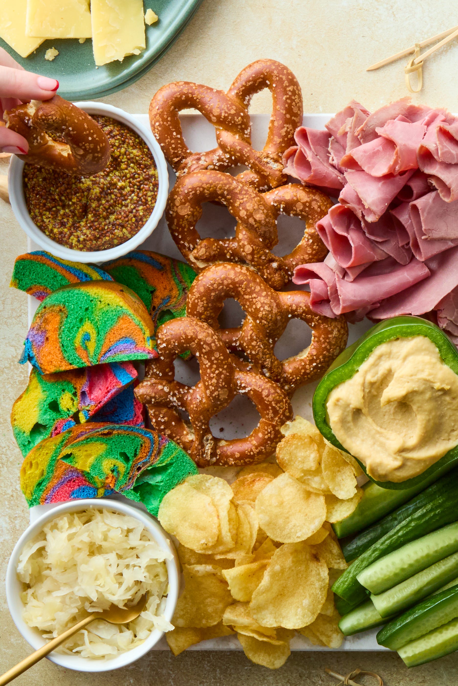 decked out board is loaded with corned beef, irish cheddar, kettle cooked potato chips, hard pretzels, rainbow bagel chips, and fresh veggies then surrounded by baby gherkin pickles, grainy mustard, sauerkraut, and dip stuffed bell peppers