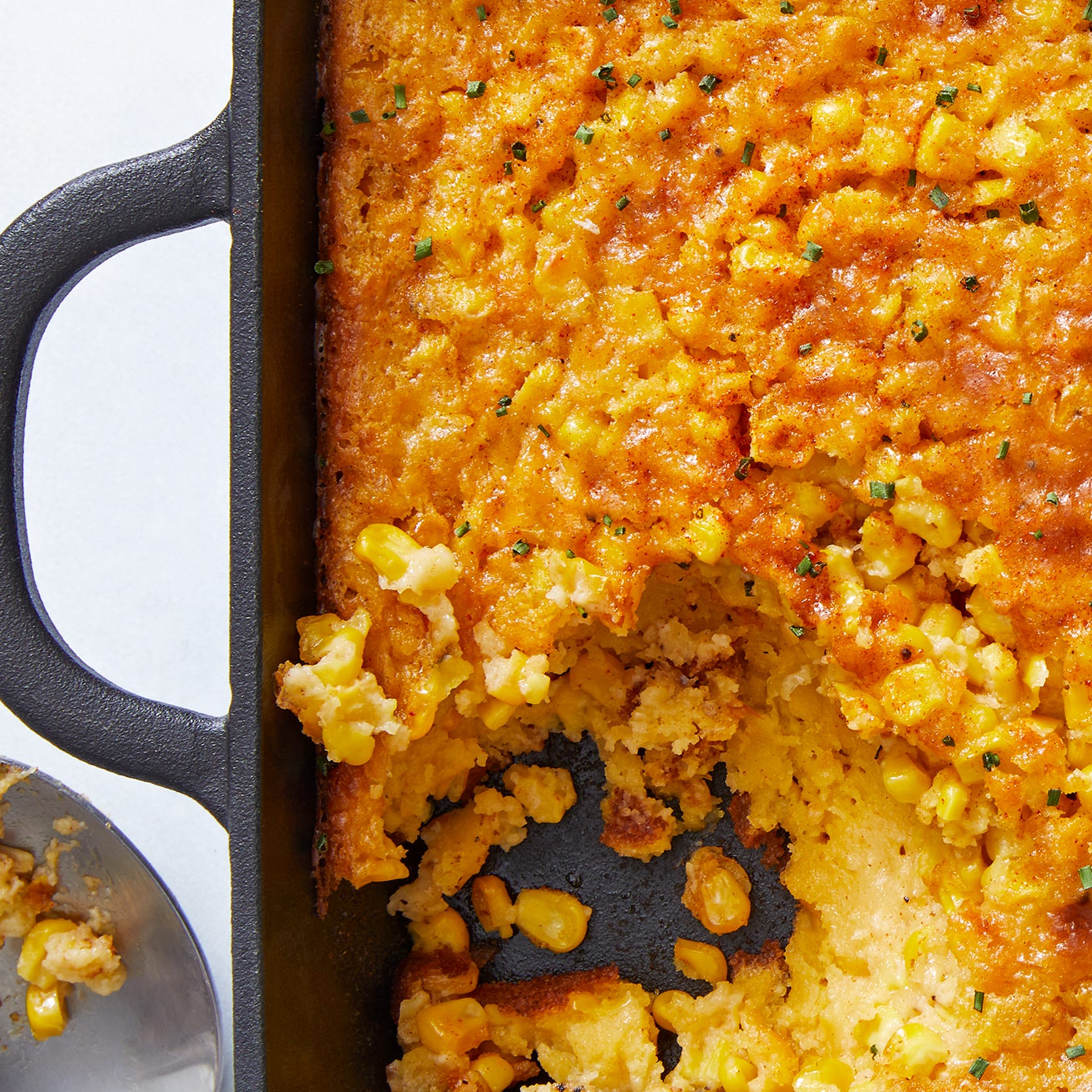 classic midwestern casserole made with jiffy muffin mix, creamed corn, and fresh corn then baked and topped with paprika and chives