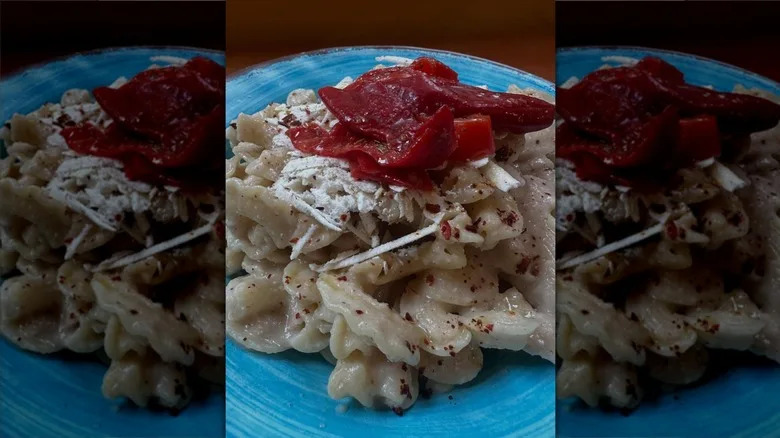 Pasta on blue plate topped with pepperoncini