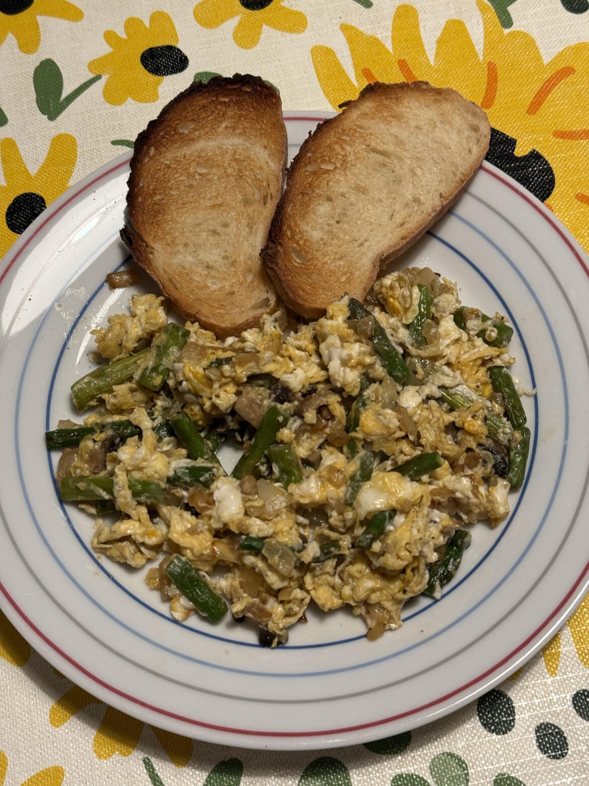Scrambled eggs with green asparagus, onion, garlic and mushrooms