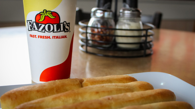 Fazoli's breadsticks served with a beverage in a branded to go cup