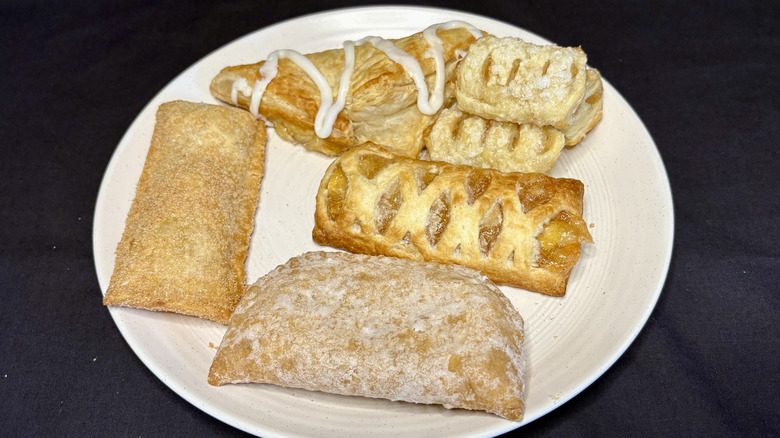 various fast food apple pies on white plate