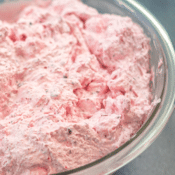 a close up of fluffy cranberry salad in a large glass bowl