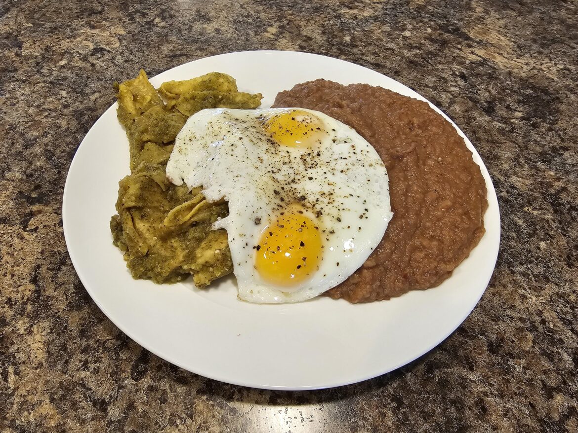 Chilaquiles & refritos with a couple of fried eggs on it