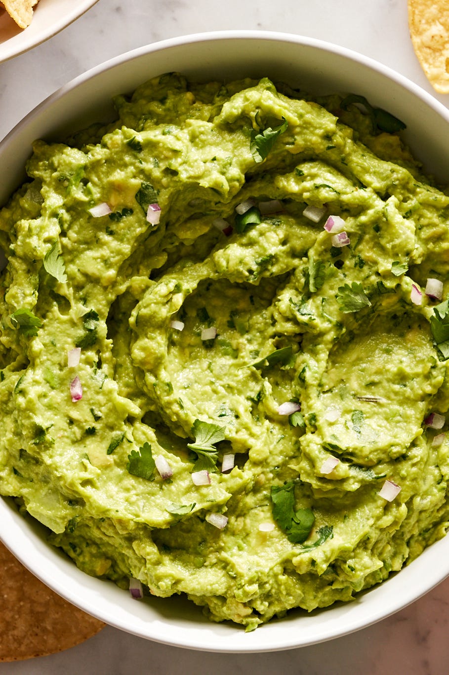 guacamole with diced red onion, cilantro, and with chips