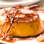 a close up of caramel flan on a white plate