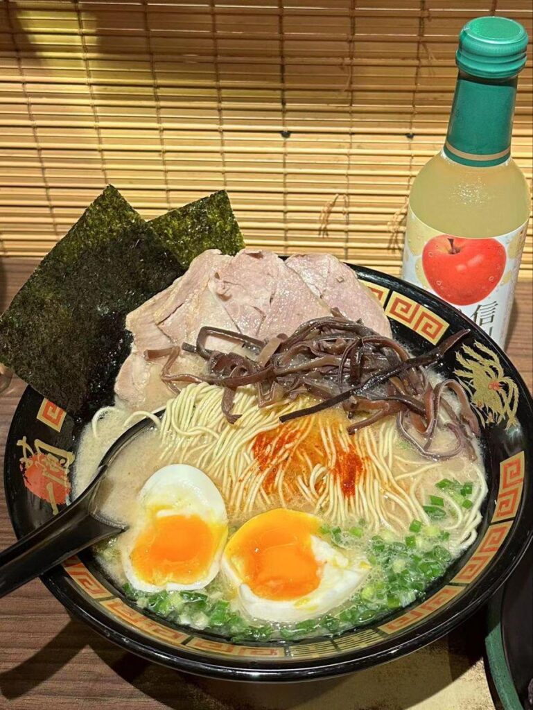 Rich tonkotsu ramen with chashu pork, soft-boiled eggs, wood ear mushrooms, and spicy paste from a ramen bar in Japan