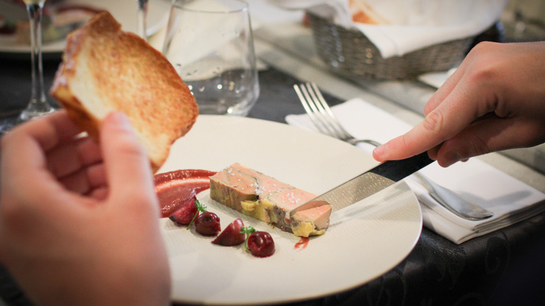 Hands spreading foie gras