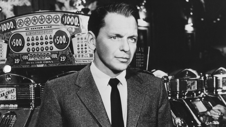 Black and white photo of Frank Sinatra in front of slot machine