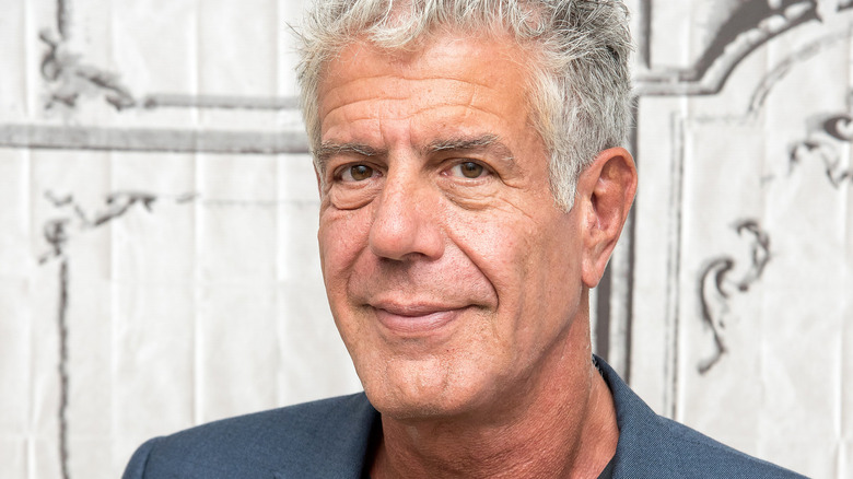 Anthony Bourdain looks at the camera with a grin