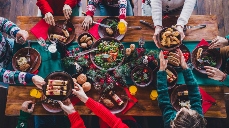 A view of a holiday table from above with people in festive sweaters