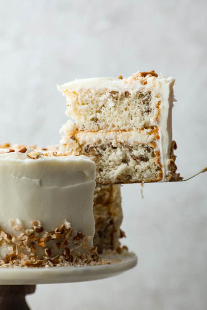 Take a bite of heaven with every forkful of this dreamy Italian cream cake. It's rich and nutty, covered with the most amazing cream cheese frosting! It's great for special occasions, but really, there's no wrong time to make it! A slice of Italian cream cake being served with a cake spatula.
