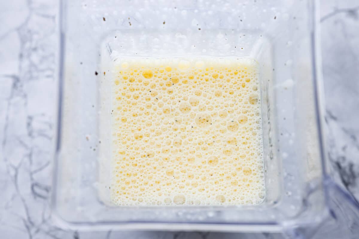 In a blender, add the eggs, cottage cheese, salt, pepper, and dried basil. Ingredients all blended up in the blender.