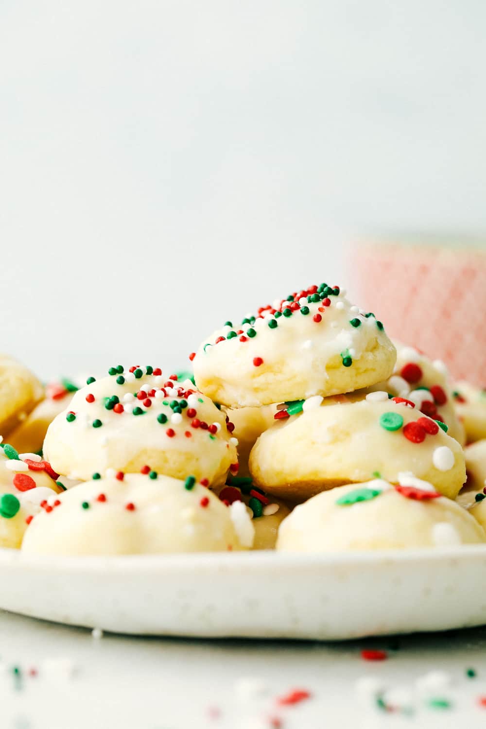 Italian Christmas Cookies are soft, buttery, fluffy and melt in your mouth delicious. Flavored with a hint of vanilla and a sweet glaze, these tasty treats are a perfect holiday treat. Take them to your next cookie exchange, party or just for fun occasion! Sweet, buttery Italian Christmas Cookies
