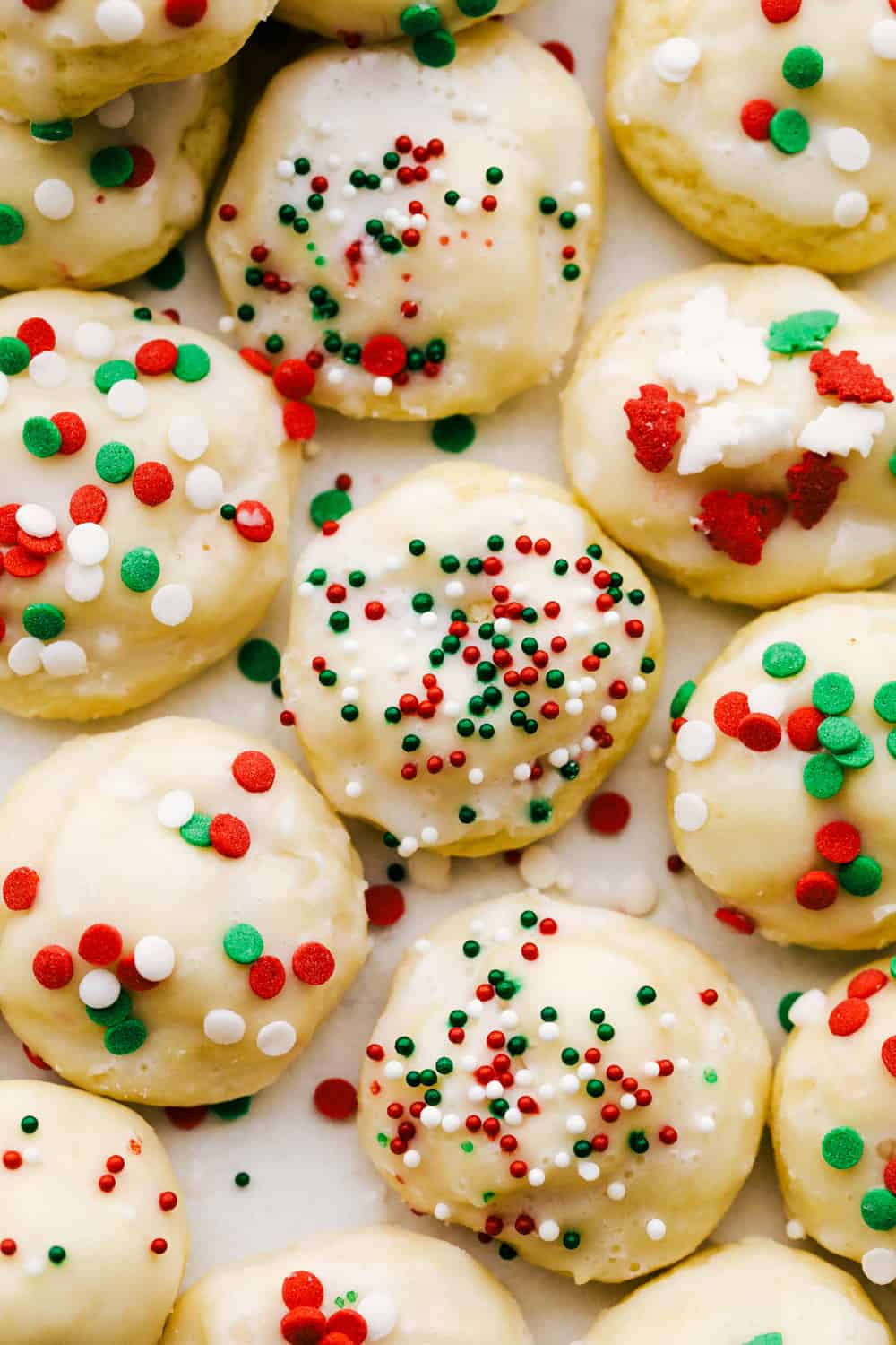Italian Christmas Cookies are soft, buttery, fluffy and melt in your mouth delicious. Flavored with a hint of vanilla and a sweet glaze, these tasty treats are a perfect holiday treat. Take them to your next cookie exchange, party or just for fun occasion! Red, white and green decorated Christmas Italian cookies