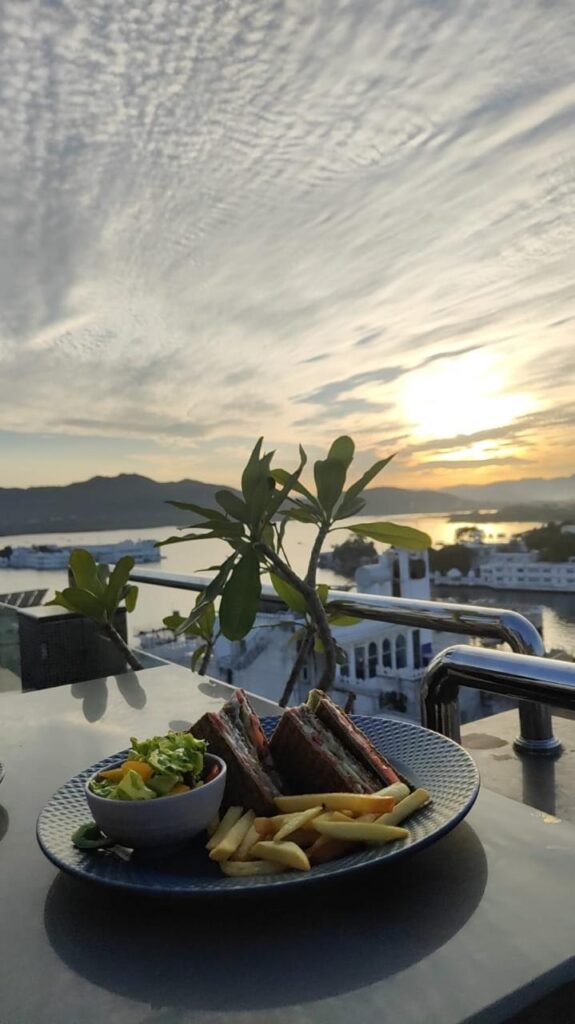Sunset Dining at Lake Pichola – A Serene View with Sandwiches and Salad