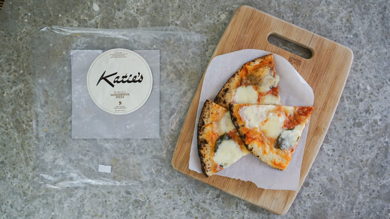 Katie's Burrata Margherita Frozen Pizza next to slices on cutting board