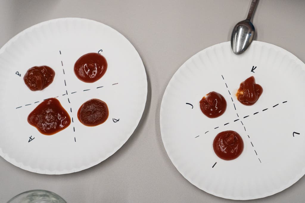 Two plates with dollops of ketchup (four on the left, three on the right) separated by dotted lines intersecting them and labeled with letters A through L.