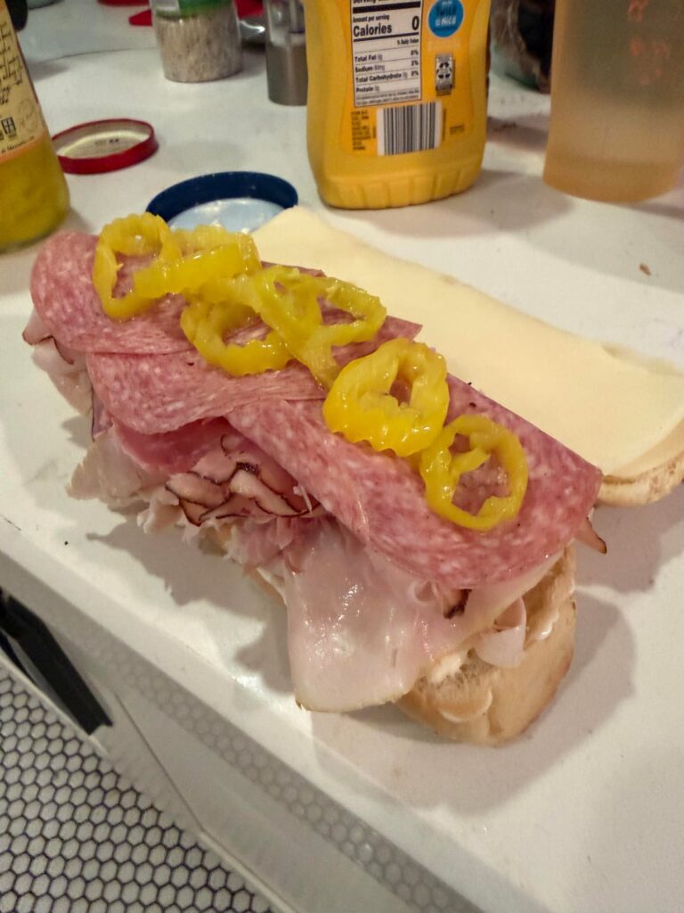 Toasted ham, turkey, salami with Swiss, lettuce and banana peppers on a sub roll. Italian dressing on the side for dipping.