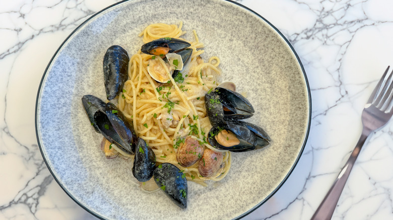 Spaghetti with mussels, clams, parsley on plate
