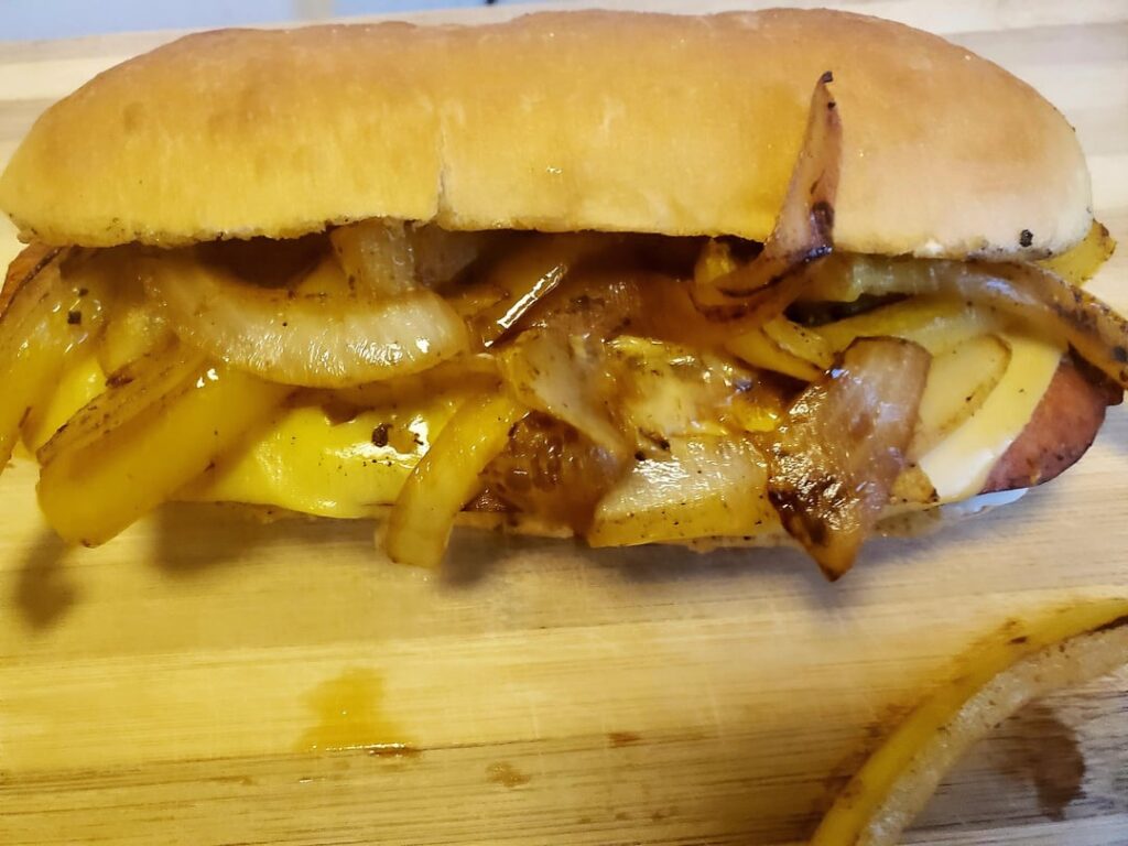 Grilled split hot sausage with onions, bell peppers, and American cheese.