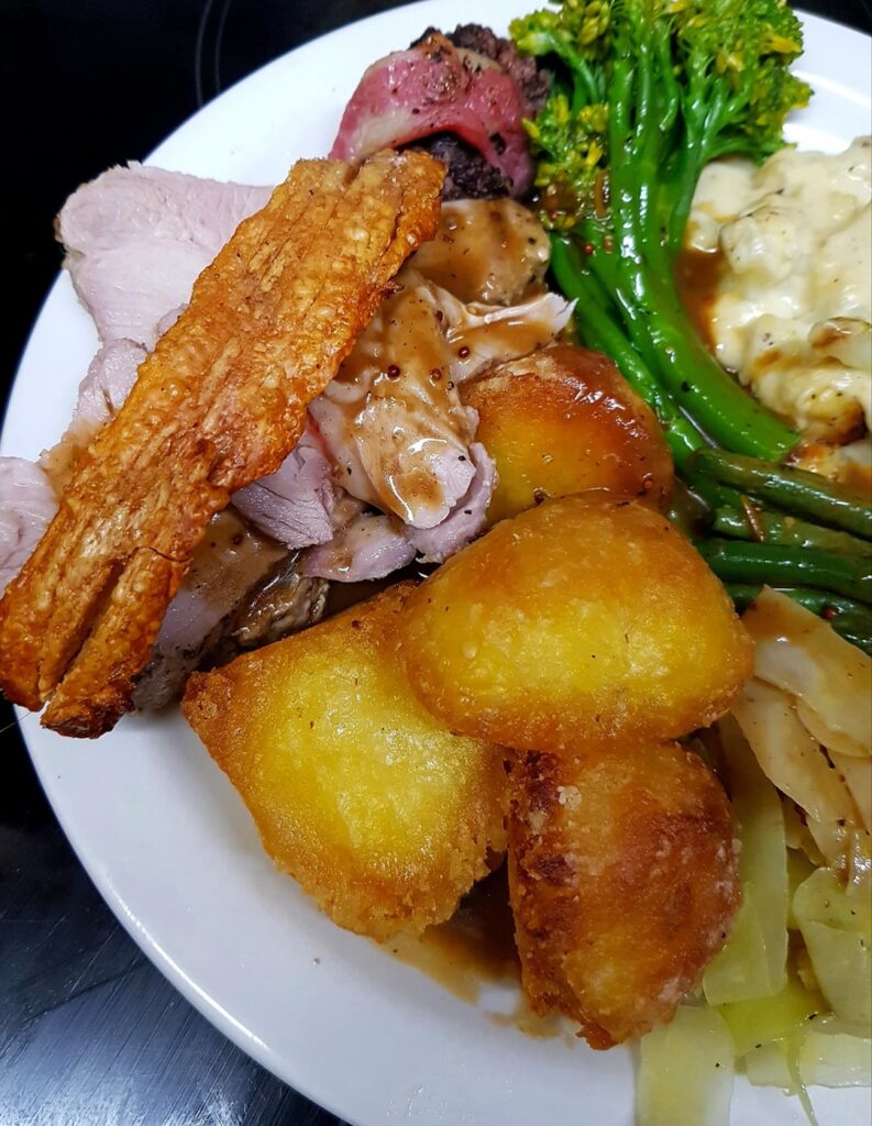 Roast Pork Shoulder, Duck Fat Potatoes, Blue Cauliflower Cheese (Mild), Buttered Cabbage, Green Beans and Broccoli, Stuffing and Bacon and Mustard Cider Gravy. And Crackling, Obviously.