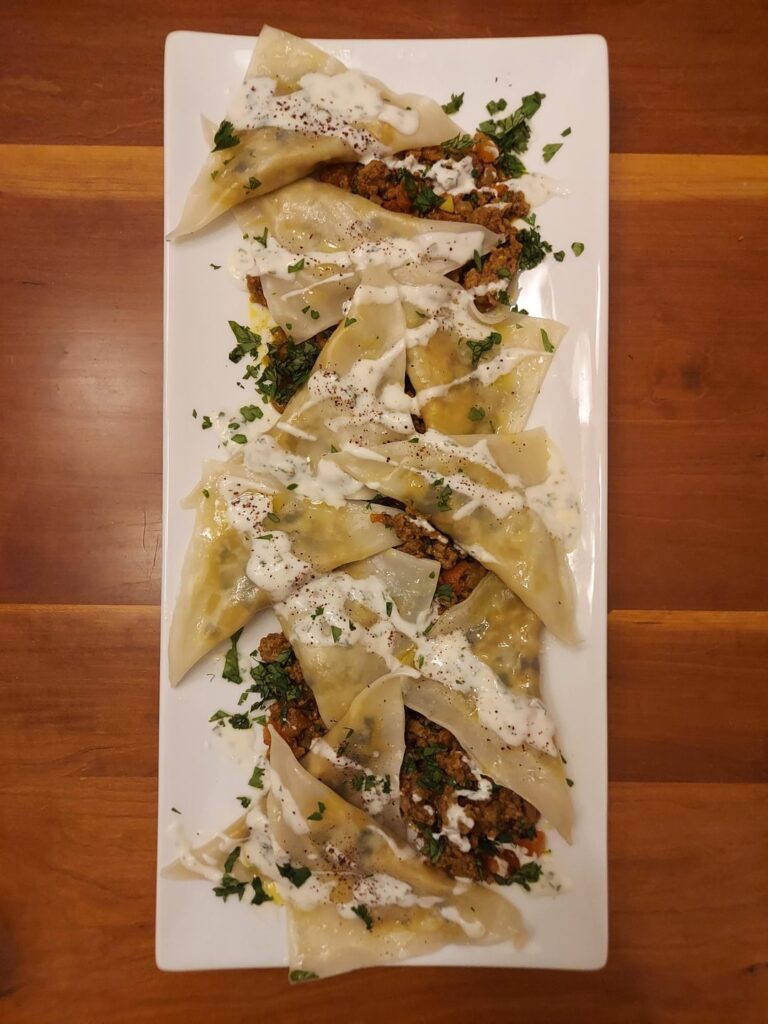 Aushak (a traditional Afghan dish with leek dumplings, minced meat and yogurt sauce)