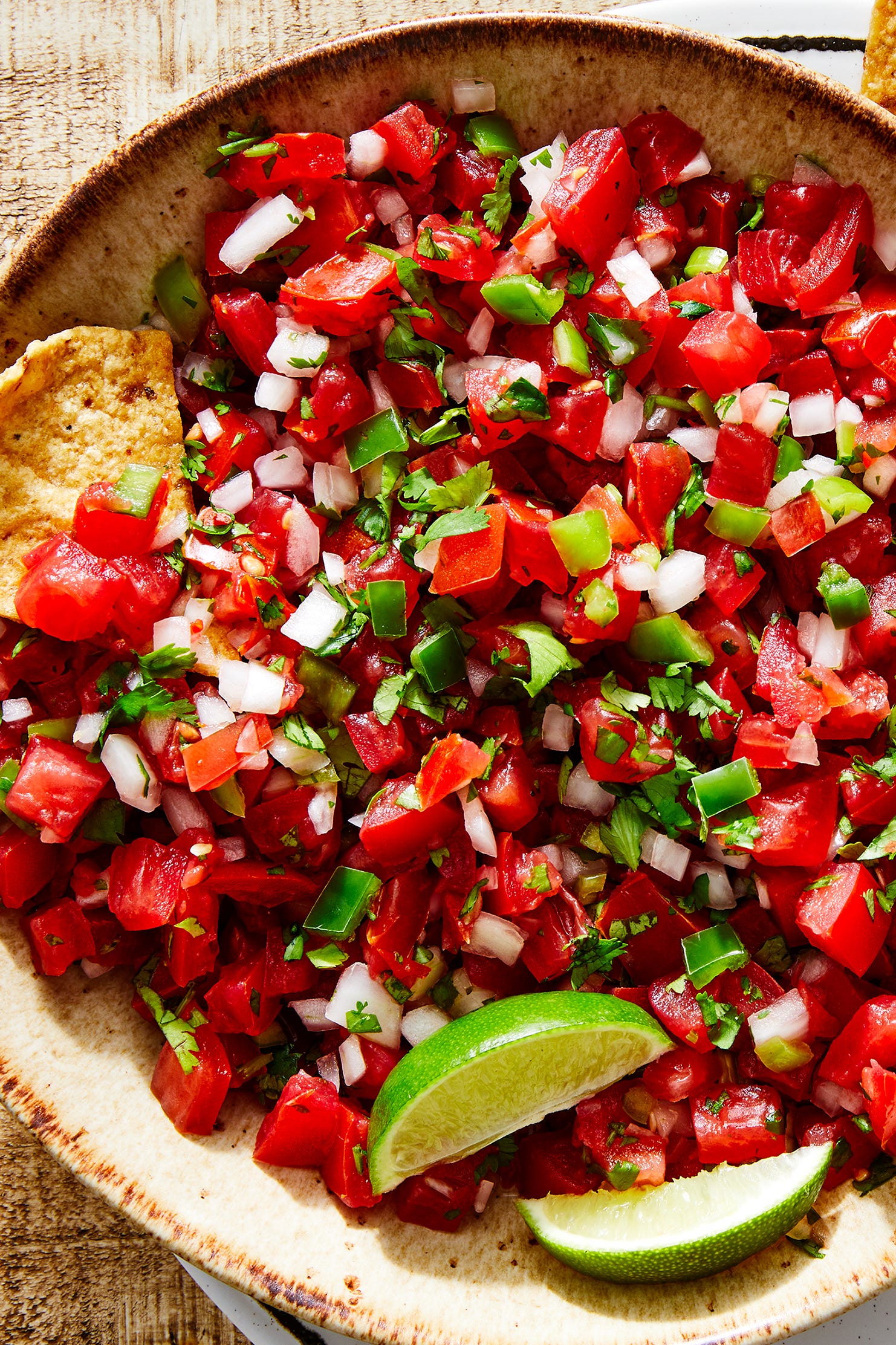 tomatoes, onion, peppers, and fresh cilantro mixed in a bowl with lime to make pico de gallo
