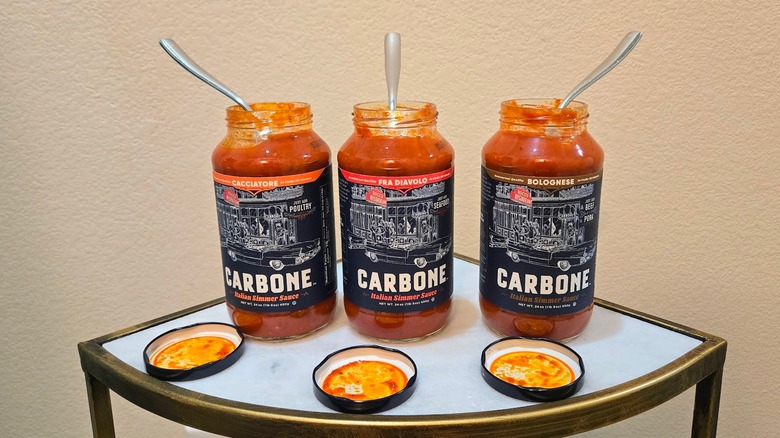 Jars of Carbone simmer sauce with spoons in them