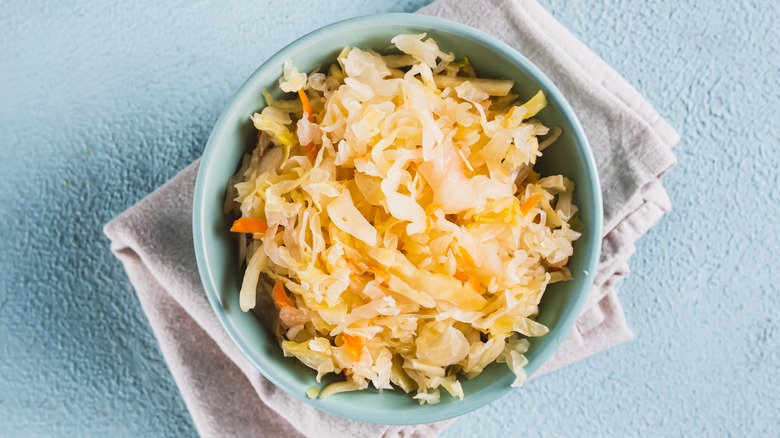 Sauerkraut with carrots in bowl on towel