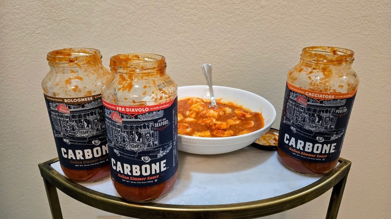 Open jars of Carbone simmer sauces with bowl of shrimp